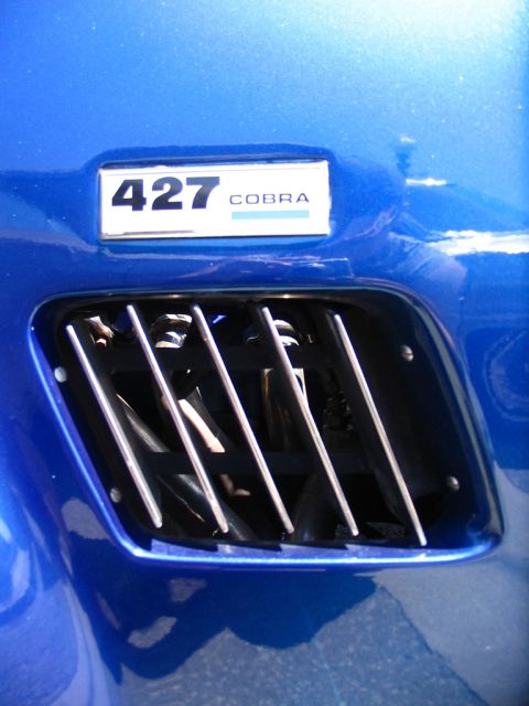 1993 Ford Taurus - Close-up of a blue car's fender, a '427 Cobra' badge and a prominent side vent.