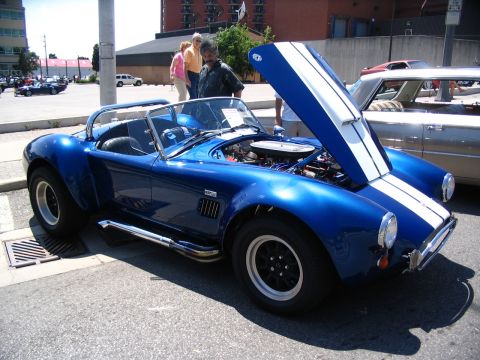 1993 Ford Taurus - Blue convertible sports car with white stripes and open hood at a car show.