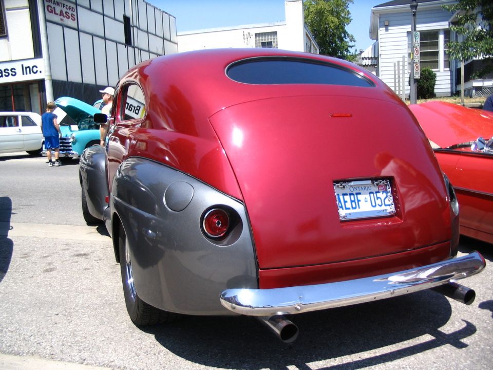 Rear view of a red and grey classic car with Ontario license plate AEBF-052
