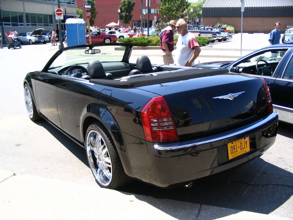 Black convertible with chrome wheels and a yellow license plate