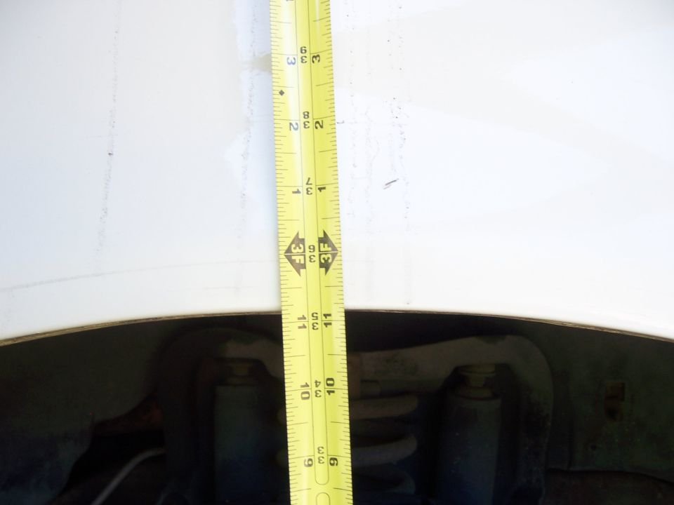 Measuring fender gap over vehicle suspension with a tape measure