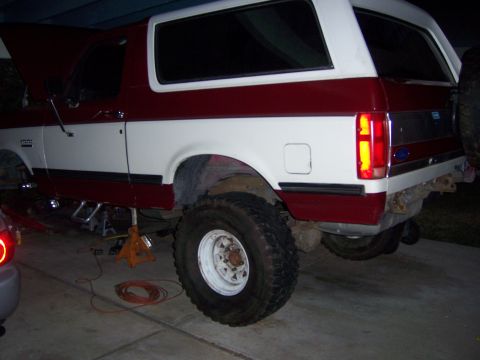 1991 Ford Bronco - This two-tone red and white 1991 Ford Bronco is shown on jack stands, possibly for a lift kit installation.