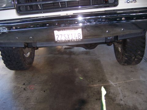 1991 Ford Bronco - Close-up of the front underside of a lifted 4x4 vehicle, showing the differential and tires.