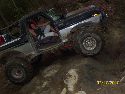 1978 Ford Bronco - Modified 1978 Ford Bronco tackling a challenging rocky trail with occupants inside.