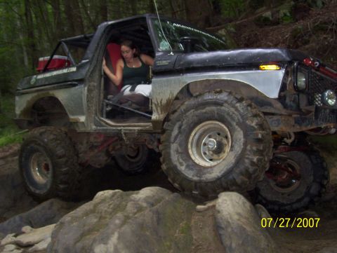 1978 Ford Bronco - This heavily modified truck is navigating a rocky trail, with a woman seated inside.