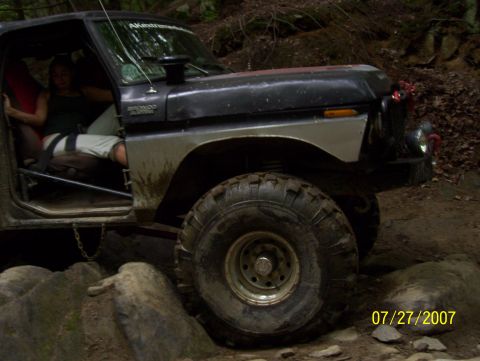 1978 Ford Bronco - A 1978 Ford Bronco navigates a rocky trail, with a person seated in the driver's position.