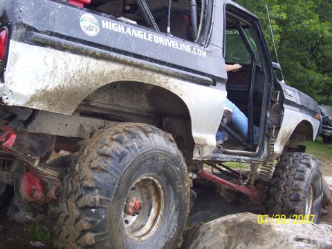 1978 Ford Bronco - This heavily modified SUV is covered in mud and appears to be navigating a rocky obstacle course.