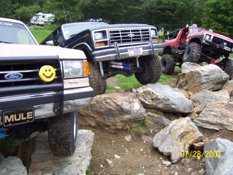 1978 Ford Bronco - Modified off-road vehicles, including a 1978 Ford Bronco, tackle a challenging rocky trail.