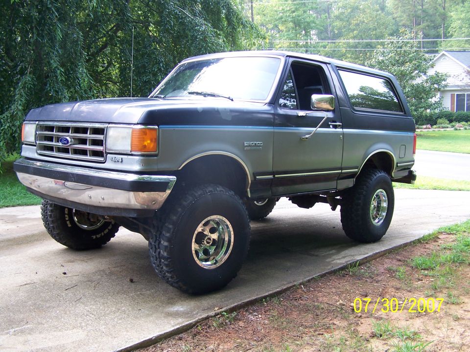Lifted Ford Bronco with aftermarket wheels parked on a driveway