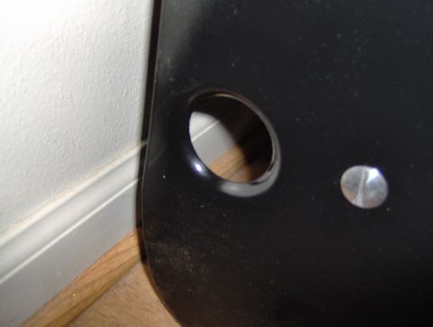 1978 Ford Bronco - A close-up of a black plastic component, possibly from a vehicle's interior, showing a hole and a fastener.