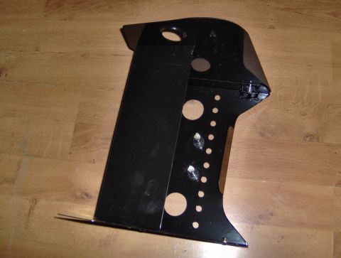 1978 Ford Bronco - A black metal part, possibly from a vehicle's interior, rests on a wooden floor.