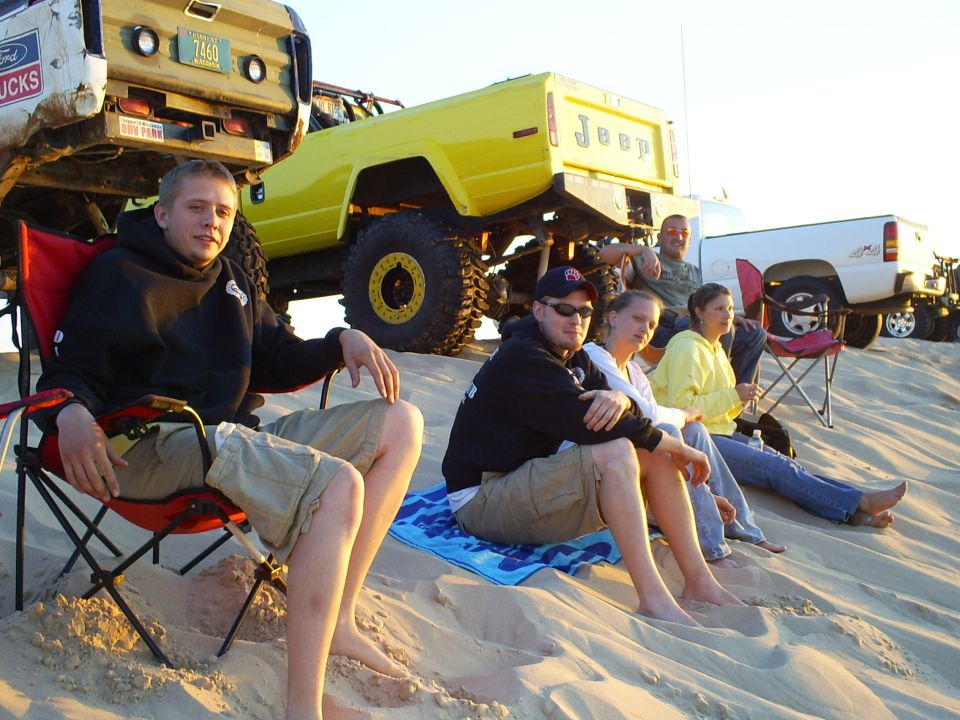 Yellow Jeep pickup truck with large tires, and a lifted Ford truck with a license plate reading "7460 ALABAMA"