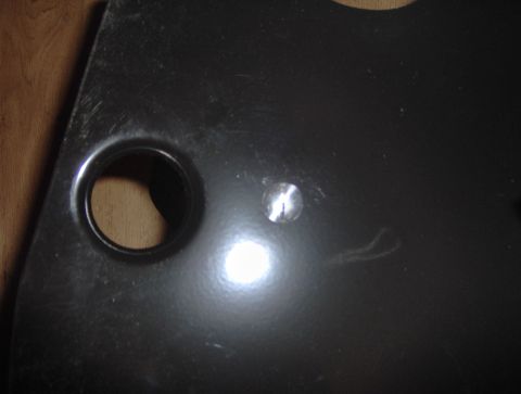 1978 Ford Bronco - A black painted metal part, possibly from a vehicle's interior, is shown with two holes.
