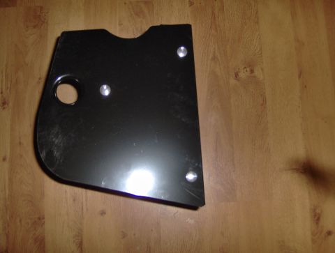 1978 Ford Bronco - A black metal part with a circular hole and three rivets is shown on a wooden surface.