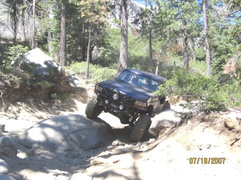 1994 Ford Bronco - This 1994 Ford Bronco navigates a challenging off-road course with large rocks and trees.