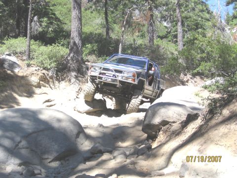 1994 Ford Bronco - A modified SUV tackles a challenging off-road course on a sunny day.