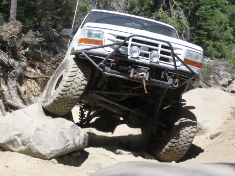 1994 Ford Bronco - This 1994 Ford Bronco is shown tackling a challenging off-road trail, with one wheel elevated on a rock.