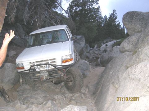 1994 Ford Bronco - White 1994 Ford Bronco tackling a difficult rocky off-road path.