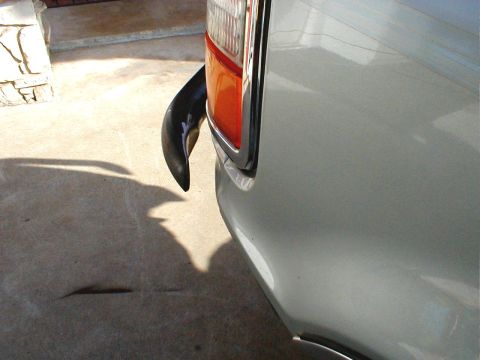1996 Ford Bronco - Close-up of the rear corner of a silver 1996 Ford Bronco, showing the taillight and bumper.