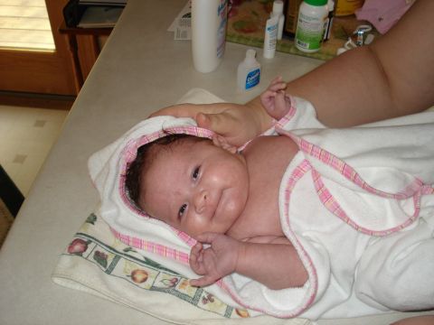 2000 Ford Crown Victoria - A baby is being held and wrapped in a towel on a counter with various bottles in the background.