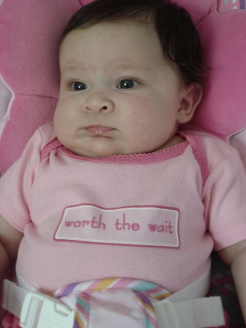 2000 Ford Crown Victoria - A baby girl wears a pink onesie with the words "worth the wait" embroidered on it.