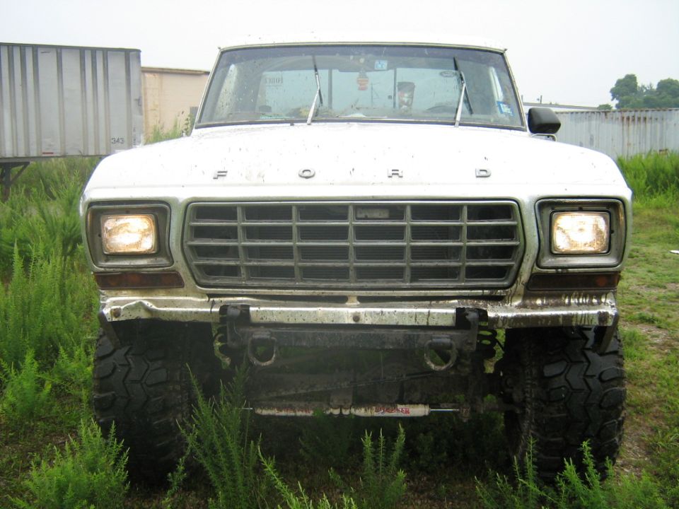 Front view of a white Ford F-Series truck with a large grille and off-road tires