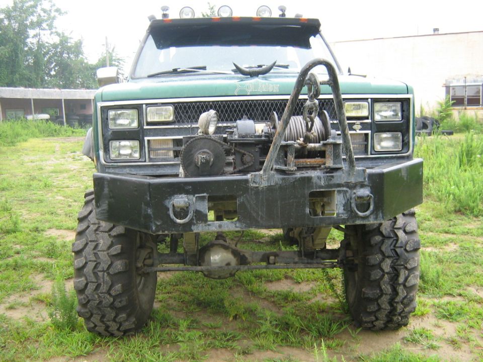Green off-road truck front view with winch and bull bar