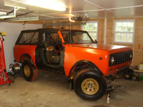 1994 Ford Bronco - Orange International Harvester Scout II in a garage, with doors removed and soft top in place.
