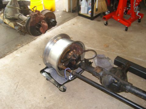 1994 Ford Bronco - Vehicle axle and wheel assembly, with a second axle in the background.