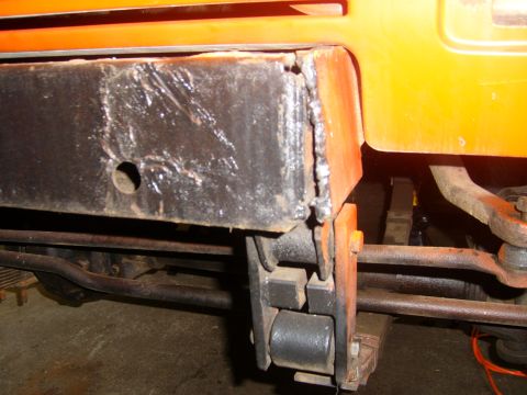 1994 Ford Bronco - This image shows a close-up view of the frame and suspension system of an orange vehicle.