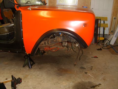 1994 Ford Bronco - Vehicle fender and wheel well assembly on jack stands, with suspension and wiring exposed.
