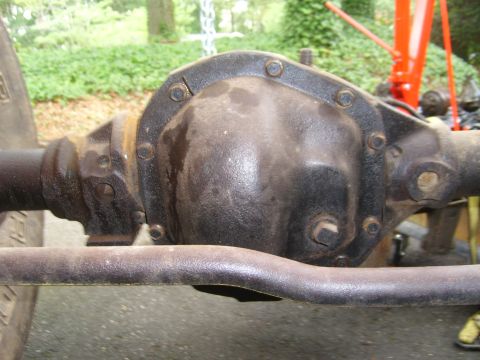 1994 Ford Bronco - Close-up view of a vehicle's rear differential assembly, showing bolted components and a tie rod in the foreground.