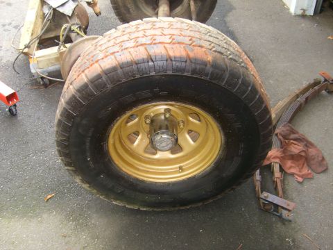 1994 Ford Bronco - Vehicle wheel and suspension components are laid out on the ground.