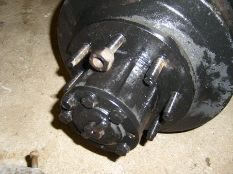 1994 Ford Bronco - Close-up of a black axle hub assembly with lug bolts and nuts visible.
