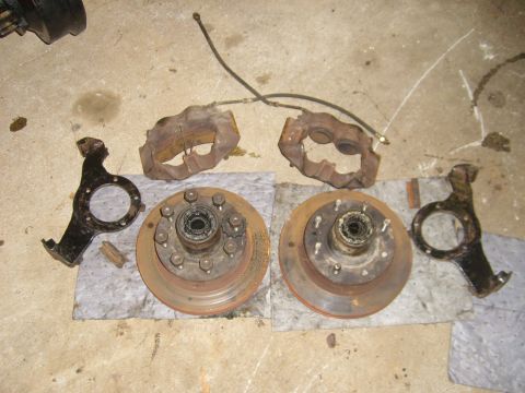 1994 Ford Bronco - Front brake components including rotors, calipers, and knuckles are disassembled and laid out.