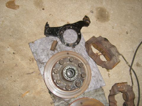 1994 Ford Bronco - Vehicle brake components laid out on a shop towel on a concrete floor.