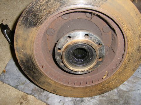 1994 Ford Bronco - Close-up of a heavily rusted brake rotor and hub assembly, showing wear and tear.