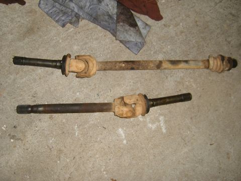 1994 Ford Bronco - Two used driveshafts are laid out on a concrete surface, showing signs of wear and rust.