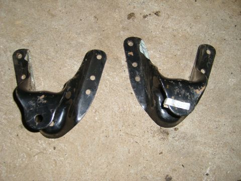1994 Ford Bronco - Two black metal leaf spring brackets are shown on a concrete surface.