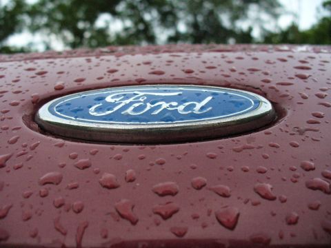 1991 Ford Probe - A close-up of a Ford emblem on a car hood covered in water droplets.