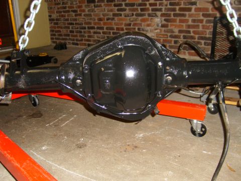 1994 Ford Bronco - A black rear axle assembly is supported by an orange jack stand, ready for installation or maintenance.