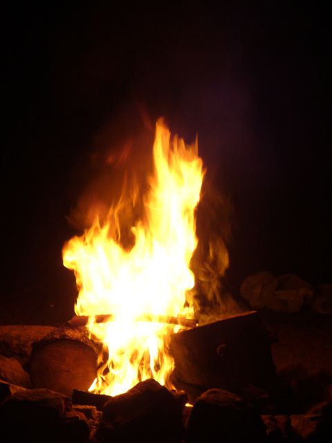 1991 Ford Probe - A bright campfire burns in the darkness, surrounded by rocks.