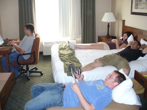 1991 Ford Probe - A hotel room scene with multiple people engaged in various activities.