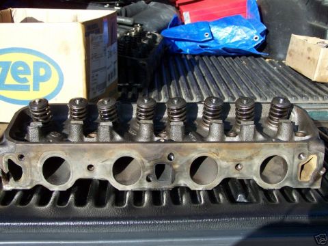 1979 Ford Bronco - Engine cylinder head with valve springs visible, resting on a truck bed. A Zep cleaning product box is in the background.