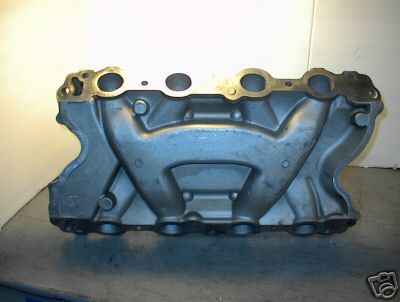 1979 Ford Bronco - A gray metal intake manifold is shown from the side, with its eight ports clearly visible.