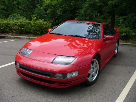 1991 Ford Probe - This red sports car, likely from the early 1990s, has distinctive pop-up headlights and a two-tone black and red exterior.