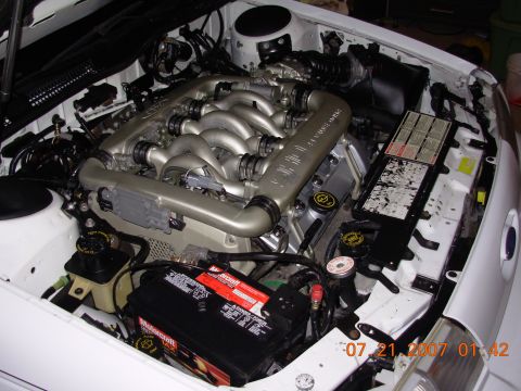 1995 Ford Taurus - Close-up view of a car's engine bay, showing the engine and battery.