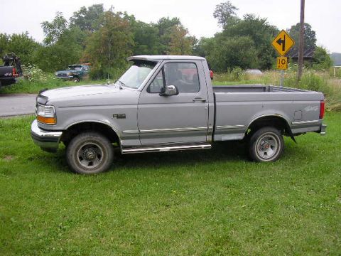 1994 Ford Probe - This 1994 Ford F-150 pickup truck is seen from the side, parked on a grassy area.