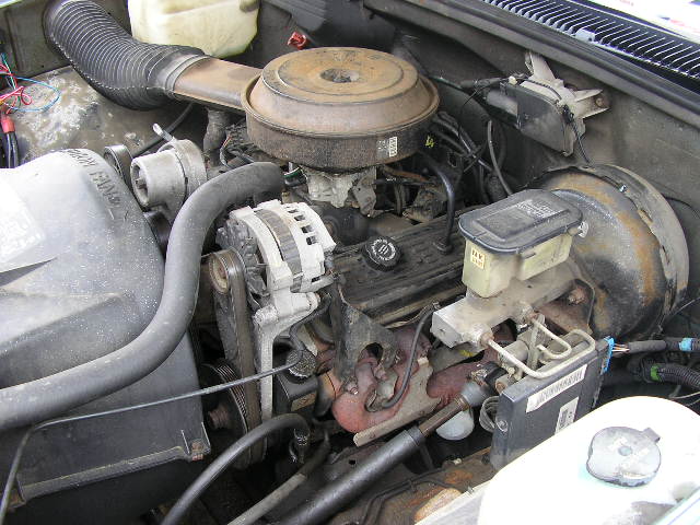 Engine bay with V8 engine, carburetor, alternator, and brake fluid reservoir