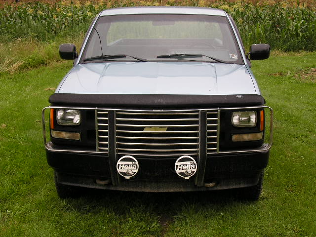 Light blue pickup truck front view with chrome grille and Hella fog lights